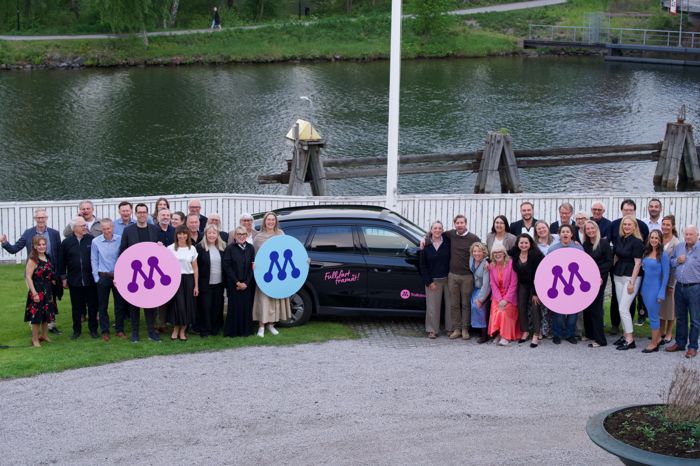 Hela laget bakom Moderaterna i Trollhättan samlat vid kanalen med M-symboler